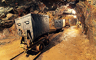old carts sitting on rails in mine